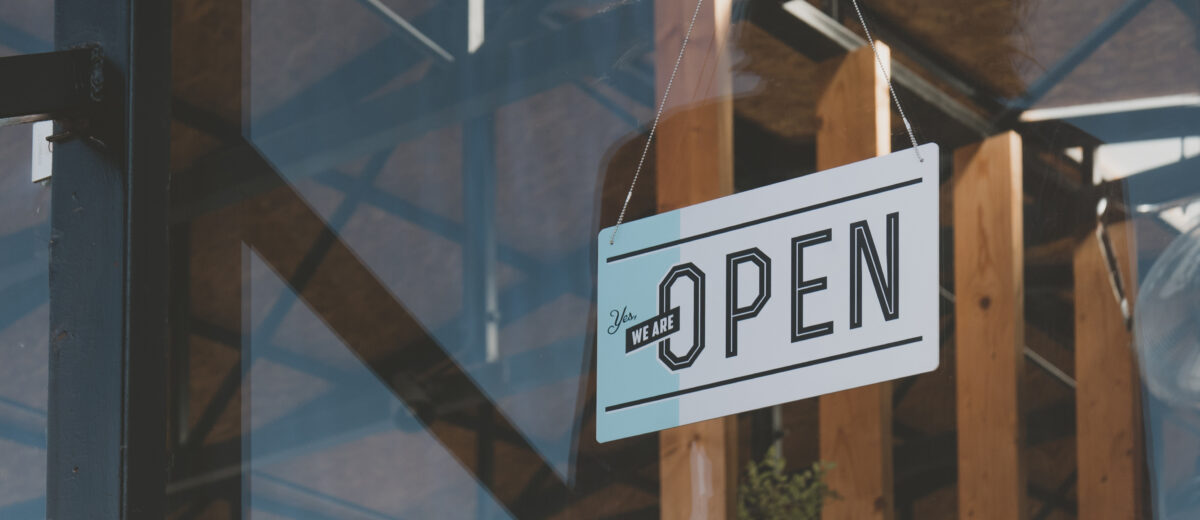 Open sign hanging on the entrance door of a small cafe