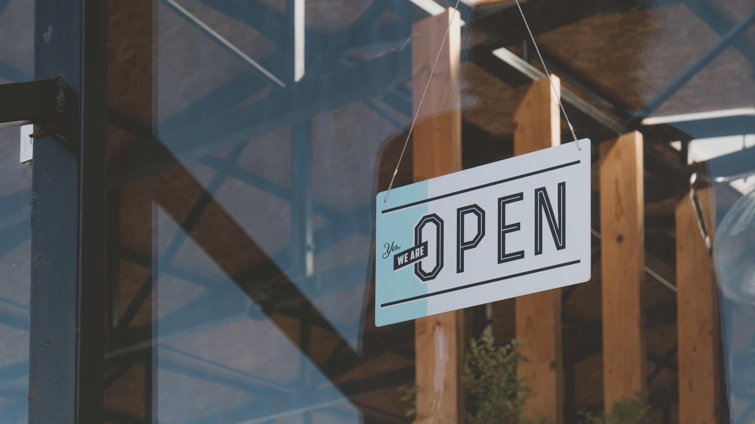 Open sign hanging on the entrance door of a small cafe